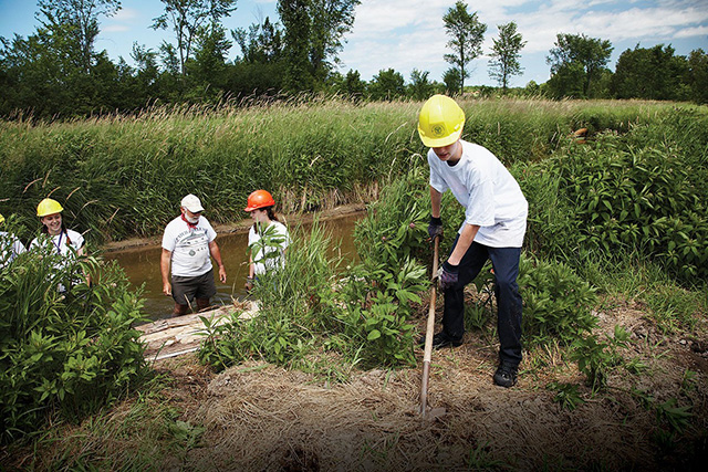 Photo d’une équipe travaillant à des activités d’intendance environnementale près d’un cours d’eau. 