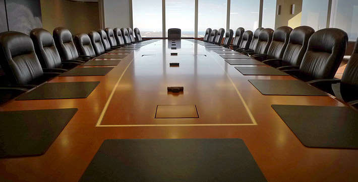 Photo looking down the length of cherry wood boardroom table in the Collaboration Boardroom