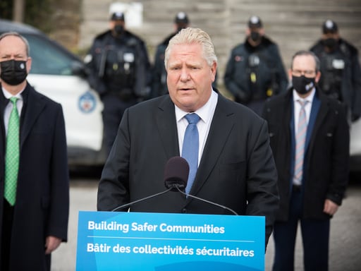 Premier Doug Ford at a podium with the sign 'Building Safer Communities'