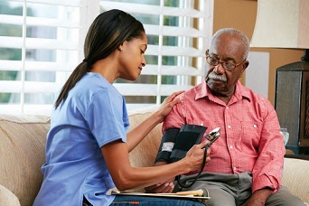 Photo of elderly man receiving medical check-up at home.